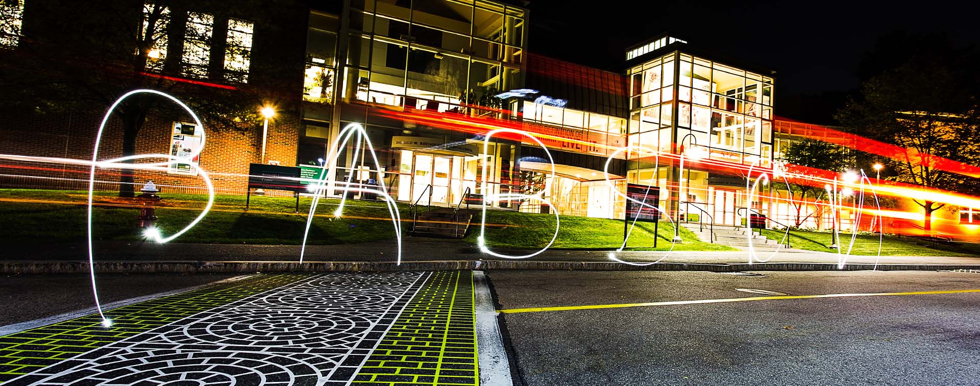 Letters spelling Babson and painted with light in front of a campus building