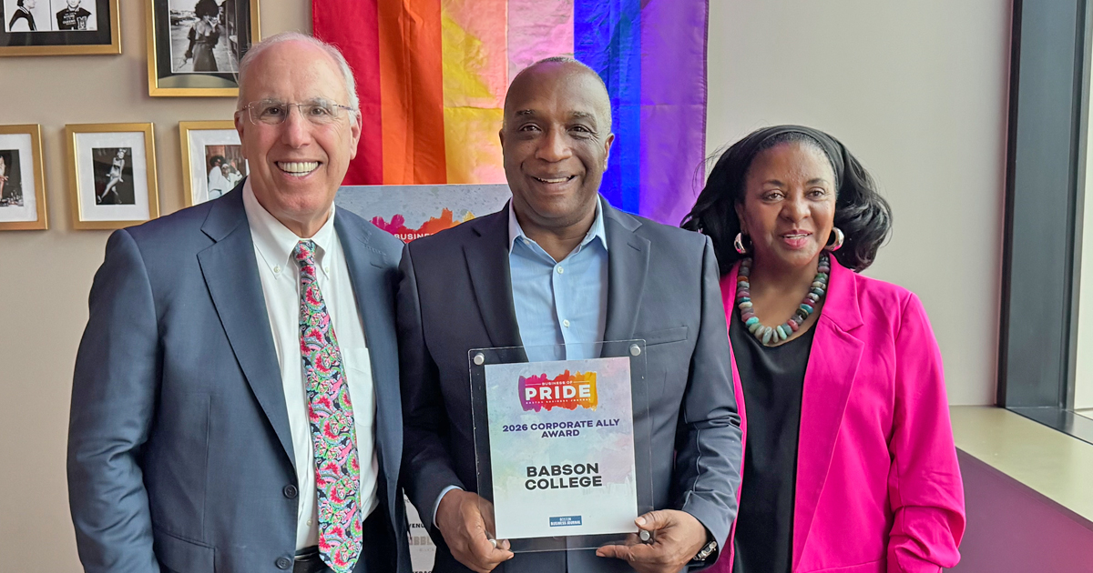 Three people accept an award during pride month