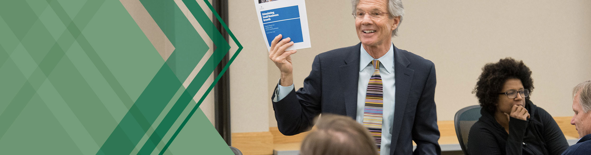 Teacher holding print material in front of a group